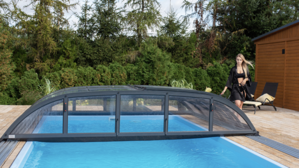 Pool med pooltak i villaträdgård som gör att poolen kan användas i alla väder.