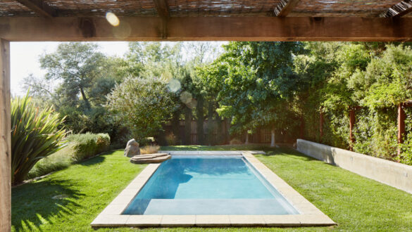 Pool i svensk villaträdgård med trädäck och modern poolmiljö